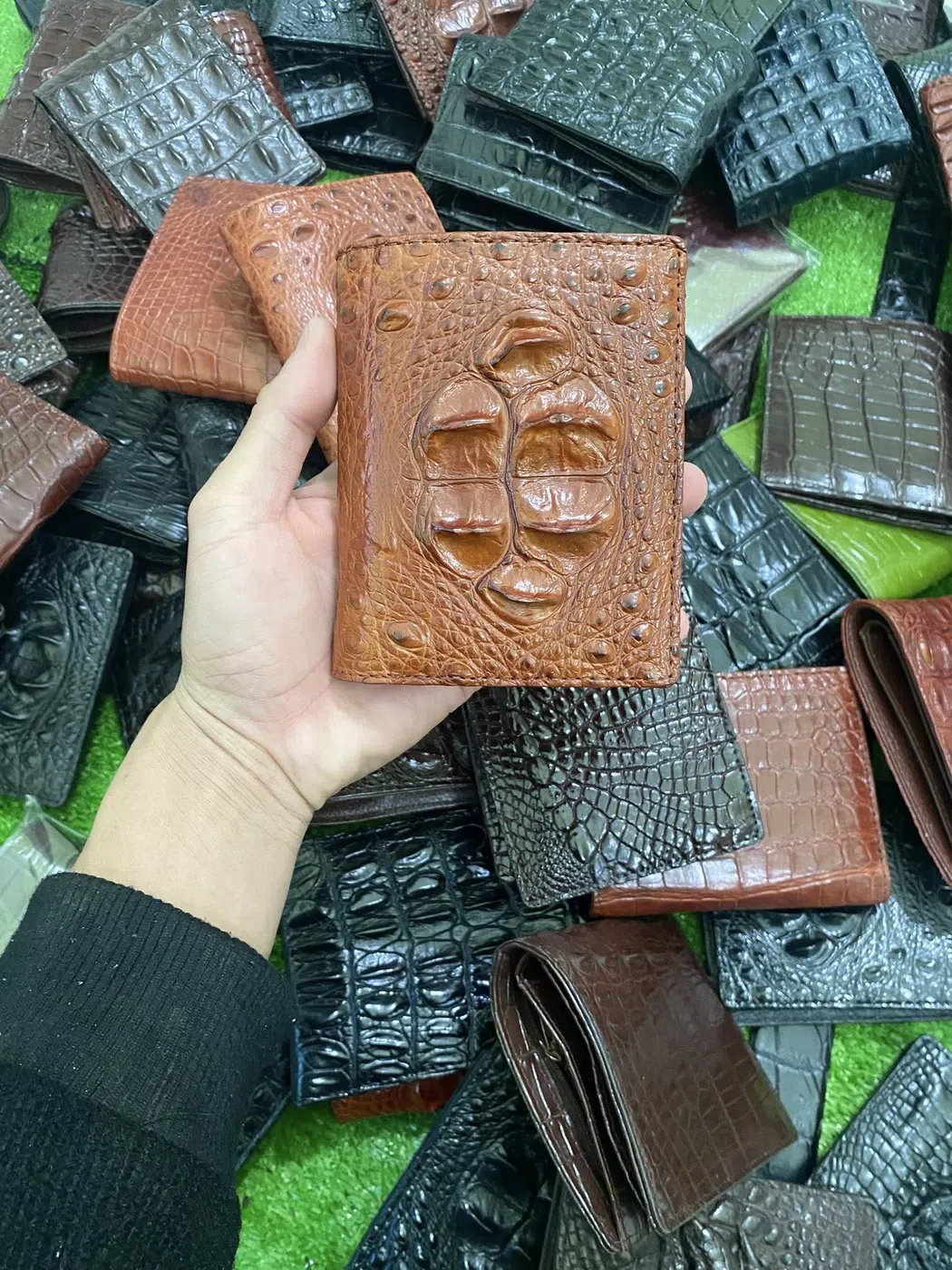 Ví da cá sấu bụng được cầm trên tay, thể hiện cấu trúc vân da tự nhiên